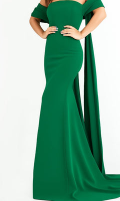 A person poses in the Long Prom Dress by Jovani 04350—a fitted emerald evening gown crafted from crepe, featuring a strapless design with draped off-the-shoulder sleeves and a floor-length hem—set against a plain white background.