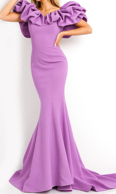 A person wearing the Jovani 04368 Off-Shoulder Long Mermaid Prom Dress in lilac, featuring dramatic ruffled shoulder detailing, stands against a plain white background.
