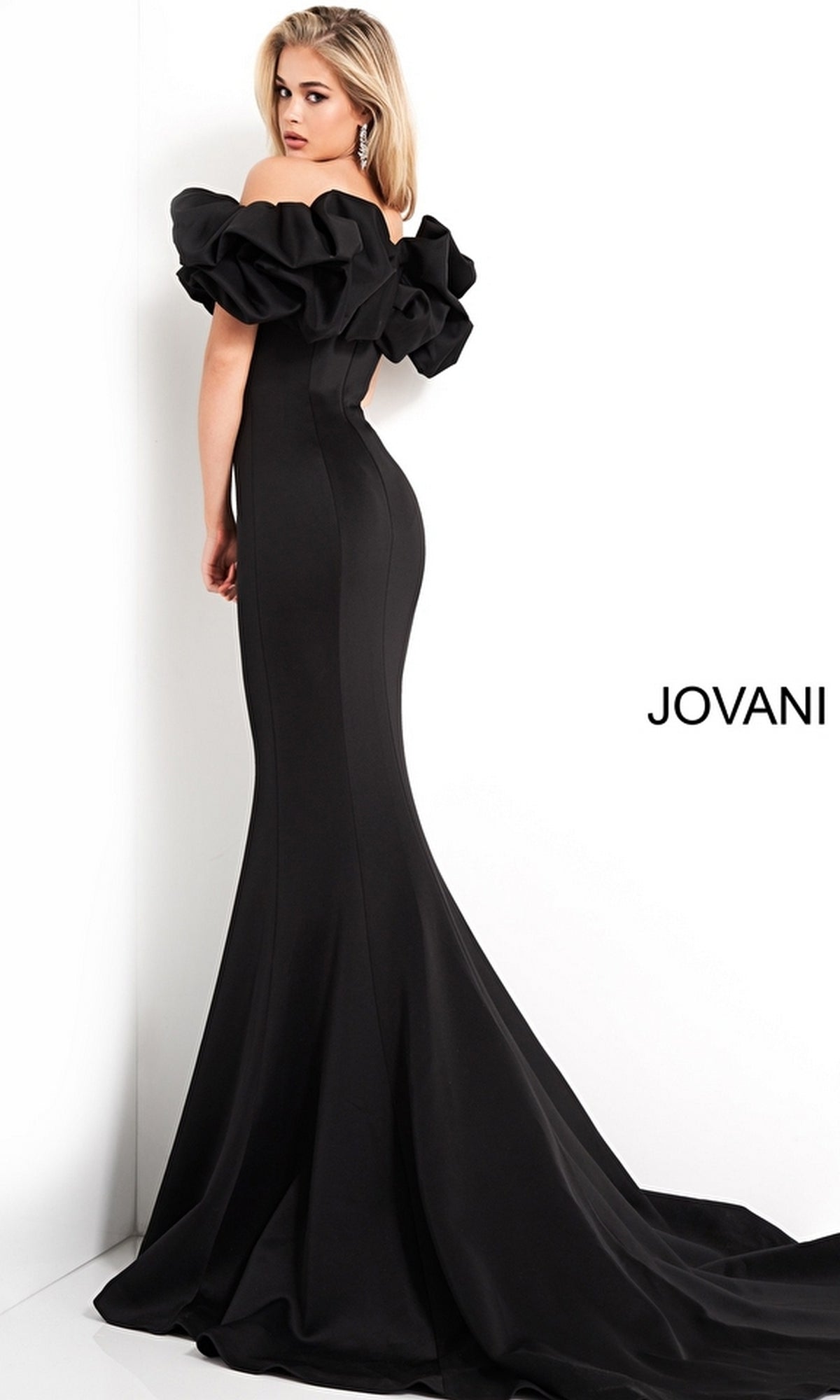 A woman stands against a white background in the Off-Shoulder Long Mermaid Prom Dress (Jovani 04368), featuring ruffled off-the-shoulder sleeves and a classic mermaid silhouette. The word 