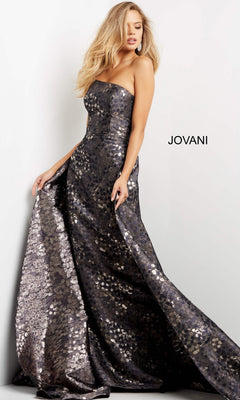 A woman elegantly wears the Long Formal Dress: Jovani 06255, a strapless, floor-length gown with a metallic silhouette and intricate sequin detailing, gracefully holding the skirt. The word “JOVANI” is displayed in the background, emphasizing this stunning designer creation.