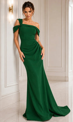 Dressed in the elegant Jovani 06723 long formal dress in emerald, a woman stands against a white, paneled wall with a wall sconce—the off-the-shoulder sheath silhouette evokes timeless classic style.