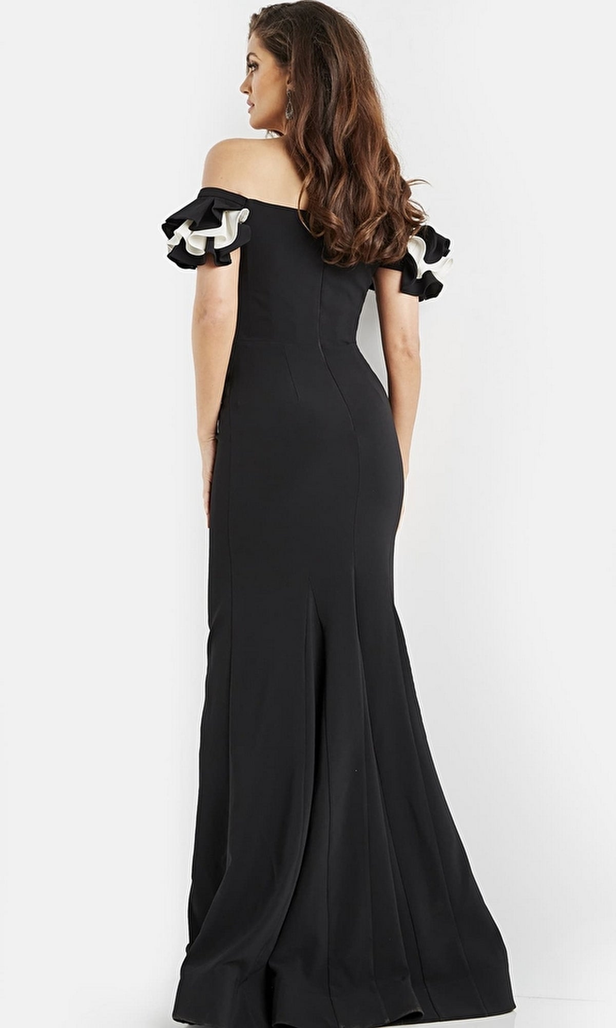 A woman stands with her back to the camera against a plain background, wearing the Long Prom Dress 07017 by Jovani—an elegant, off-the-shoulder formal gown with ruffled short sleeves.