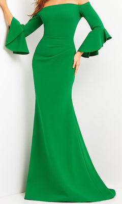 An elegant woman stands against a plain white background wearing the Bell-Sleeve Designer Evening Gown by Jovani (style 07065) in a fitted emerald design, featuring long, off-the-shoulder flared ruffled sleeves.