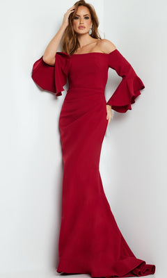 Woman wearing the Jovani 07065 Bell-Sleeve Designer Evening Gown, a floor-length, off-the-shoulder dress with flared ruffle sleeves, stands against a plain light-colored background.
