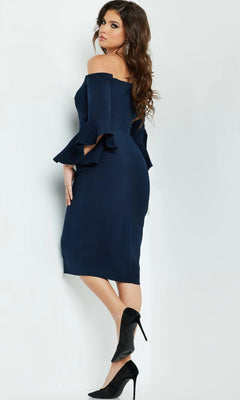 A woman wearing the Short Wedding Guest Dress: Jovani 07066, a navy off-the-shoulder sheath with elegant flared sleeves, stands sideways in black high heels against a plain light background.