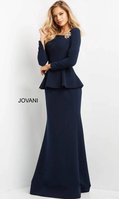 A woman stands against a white background wearing the Jovani 07131 long formal dress—an elegant navy blue gown with long sleeves, a peplum waist, and jeweled embellishment on the shoulder. The sophisticated trumpet silhouette enhances her refined look. The word “JOVANI” appears beside her.