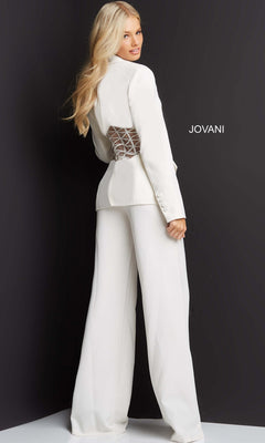 A woman models the Long Jumpsuit: Jovani 07227, featuring a sheer crisscross back detail, while standing against a dark background with “JOVANI” displayed.