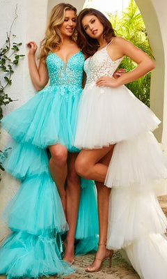 Two women pose outdoors near a white arch, wearing Jovani Ruffled High-Low Prom Dress 07263—one in aqua blue with an embroidered bodice and the other in white—both standing side by side amid greenery.