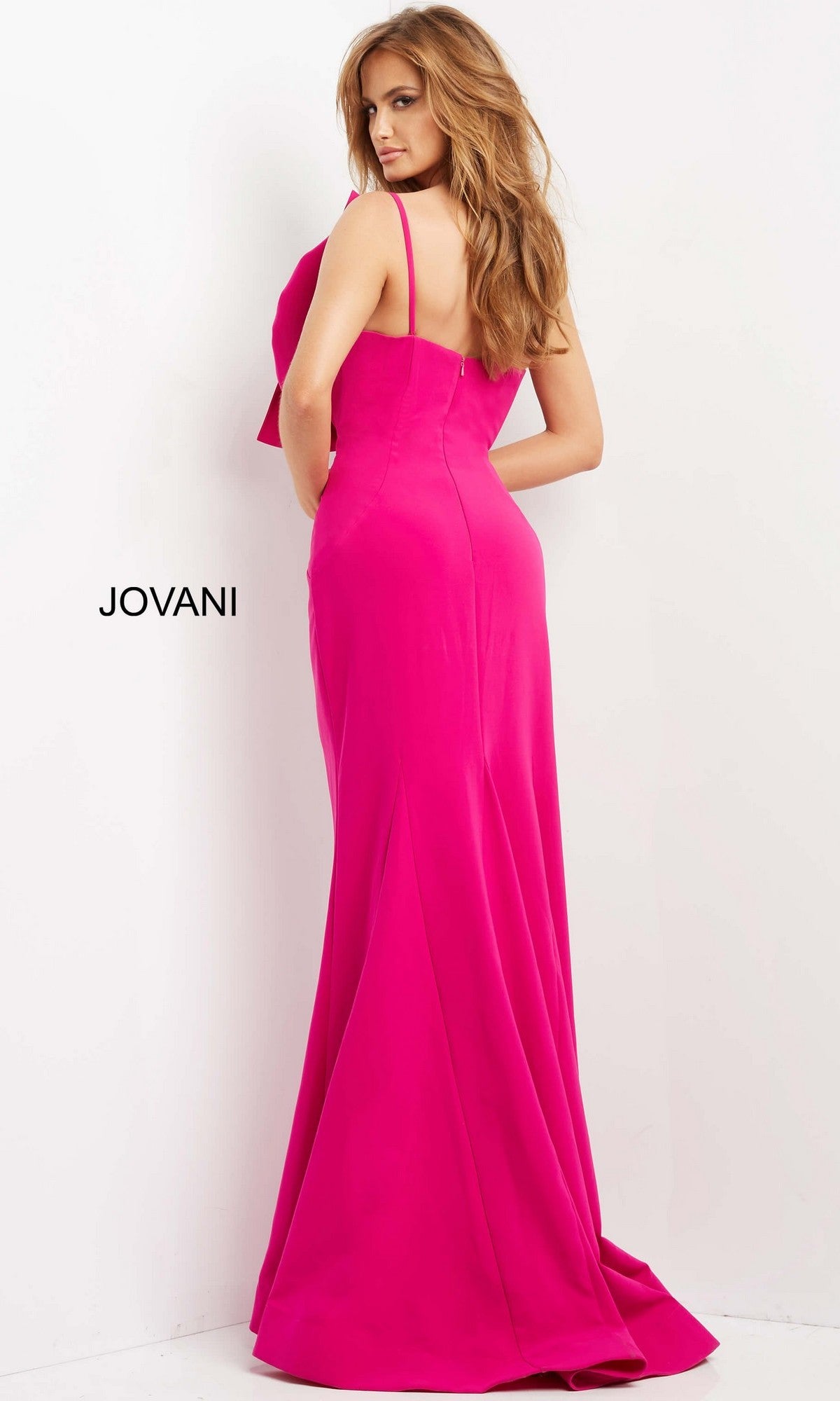 A woman models the Jovani 07306 Long Formal Dress—a vibrant pink, floor-length, sleeveless mermaid gown—standing with her back to the camera against a plain white background. The word “JOVANI” is displayed on the left.