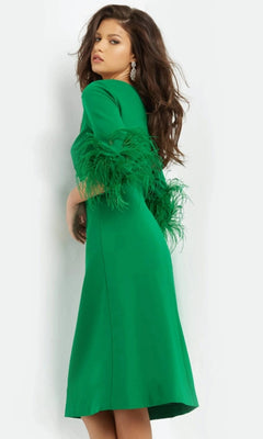 A woman poses sideways, looking over her shoulder in the Jovani 07341 Short Wedding Guest Dress—a knee-length, bright green fitted sheath dress with elegant feathered sleeves—perfect as a modest wedding guest outfit against a plain white background.