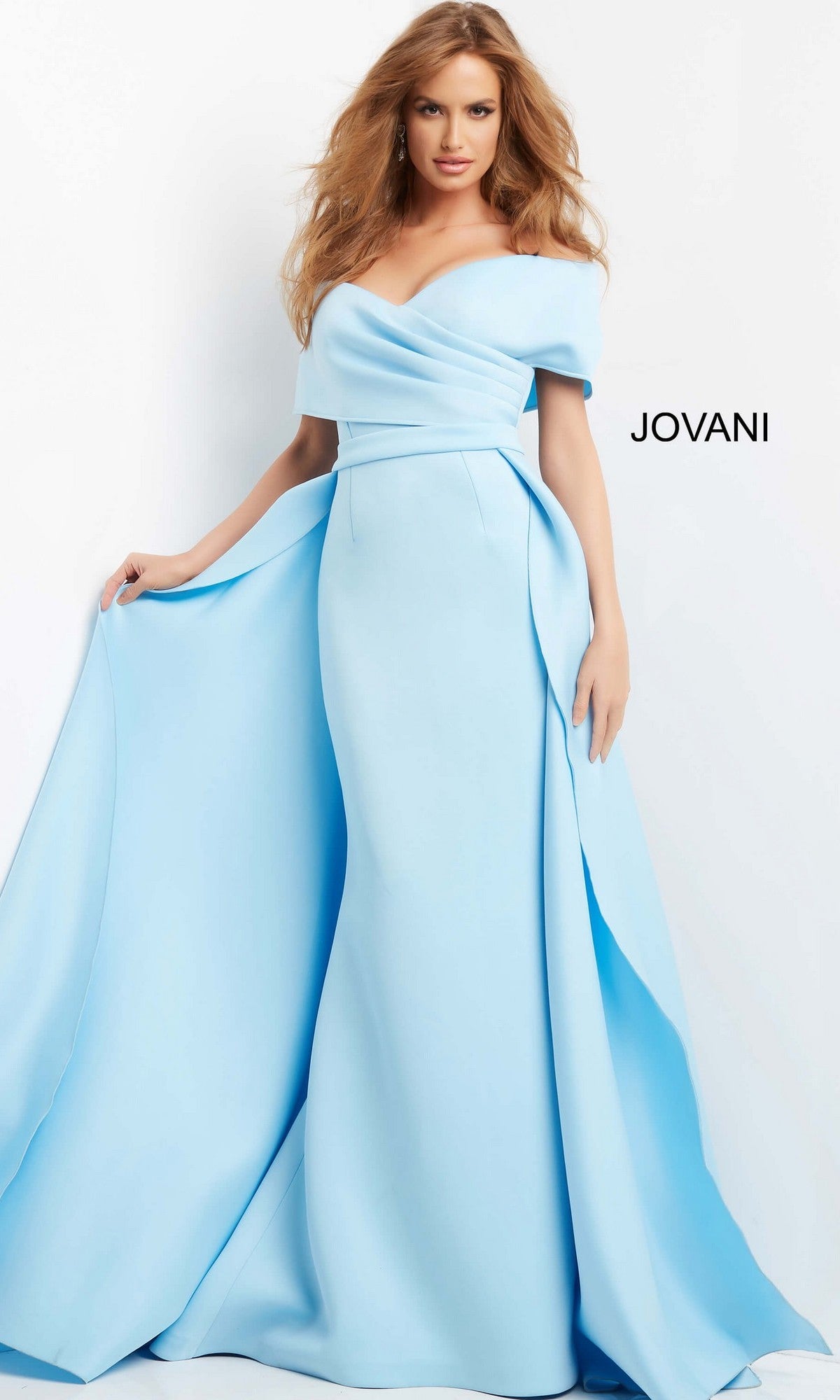 A woman models the Jovani 07443 Long Formal Dress in light-blue, featuring an off-the-shoulder design with a fitted bodice and flowing mermaid skirt, posed against a plain white background with the “JOVANI” brand name visible.