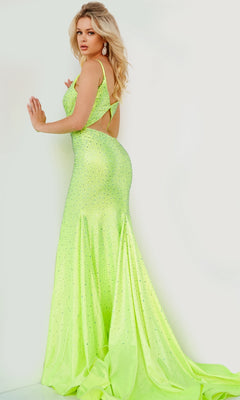 A woman poses against a light wall in the Jovani Cut-Out-Back Long Beaded Prom Dress 08157, a neon yellow-green, floor-length gown with sparkling embellishments and side cutouts—ideal for prom or formal events.