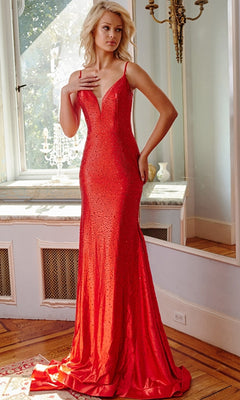 A woman stands indoors wearing the Jovani Cut-Out-Back Long Beaded Prom Dress 08157, a floor-length fitted gown with thin straps and a deep V neckline.