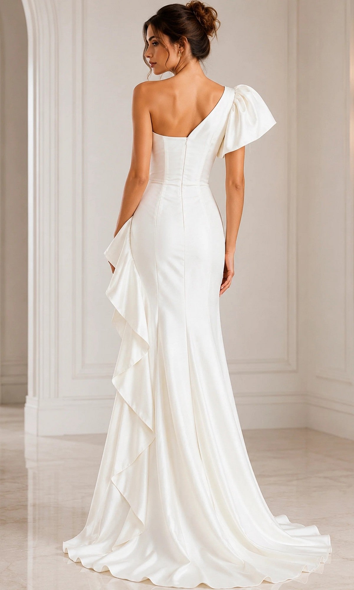 A woman stands in a bright, elegant room with her back to the camera, wearing the Jovani 09201 long formal dress—a white, floor-length Mikado gown featuring a one-shoulder design and ruffle detail.