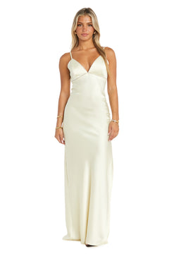A woman models the Empire-Waist Long Satin Prom Dress: Morgan 10040N, featuring thin straps and a cream color, standing against a plain white background.