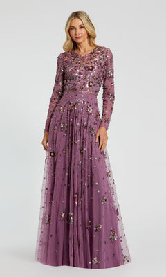 A woman wears the Mac Duggal 10063 Long Sleeve Beaded Formal Dress in lavender, adorned with floral embroidery and bead embellishments, standing against a plain background.