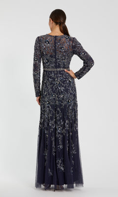 A woman faces away, wearing the Mac Duggal 10093 Long Sleeve Beaded Formal Dress featuring intricate silver and blue floral embroidery.