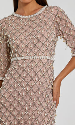 A person wearing the Beaded Long Pink Formal Dress: Mac Duggal 10099, with pearl and crystal geometric embellishments, short sleeves, and a fitted waist.