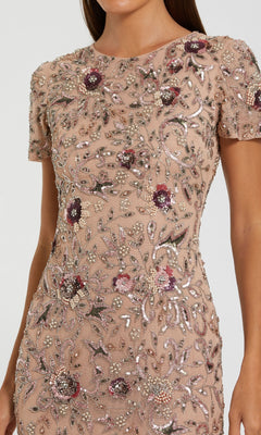 Woman wearing the Mac Duggal 10102 Beaded Midi Wedding Guest Dress, a short-sleeved, fitted beige dress adorned with intricate floral bead and sequin embroidery—perfect for parties and weddings.