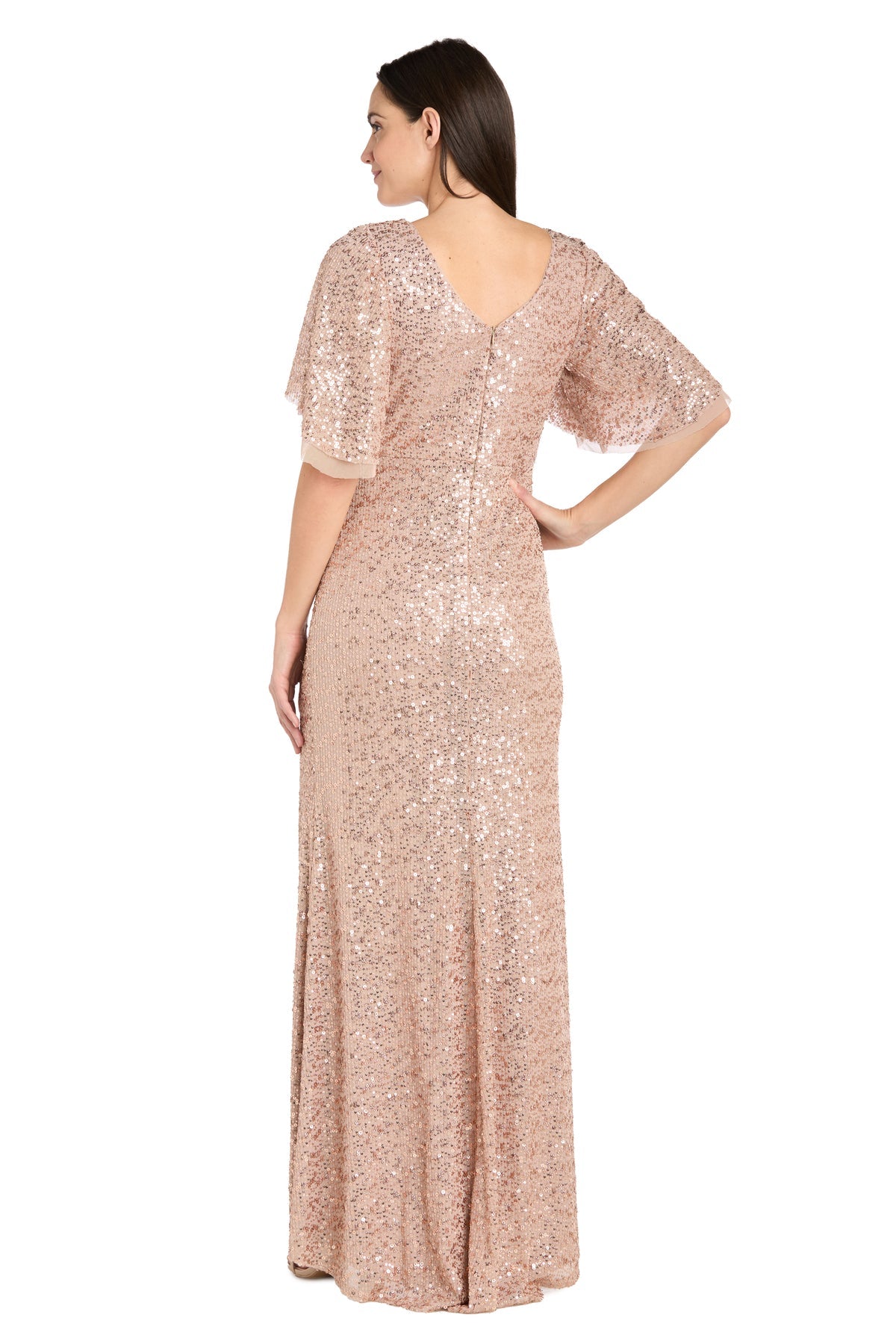 A woman faces away, showcasing the R&M Richards 1011 Rose Gold Sequin Formal Dress with short flutter sleeves, a scoop back, and an affordable price.