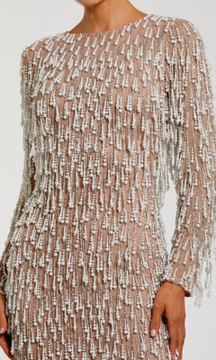 A person wearing the Mac Duggal 10120 midi wedding guest dress, featuring nude long sleeves and dense white bead and sequin embellishments with elegant pearl-beaded fringes arranged in vertical patterns.
