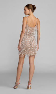 A woman stands in heels facing away from the camera against a plain backdrop, wearing the Mac Duggal 10121 Short Cocktail Dress—a glamorous, sleeveless mini dress with delicate spaghetti straps and beaded pearl fringe—a stunning choice for your next special occasion.