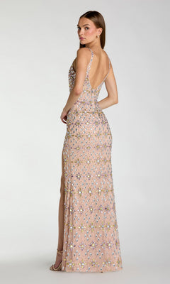 A woman stands sideways against a plain background, looking over her shoulder in the Mac Duggal 10155 Long Formal Dress—a sleeveless, floor-length gown in light pink embellished with sequins.