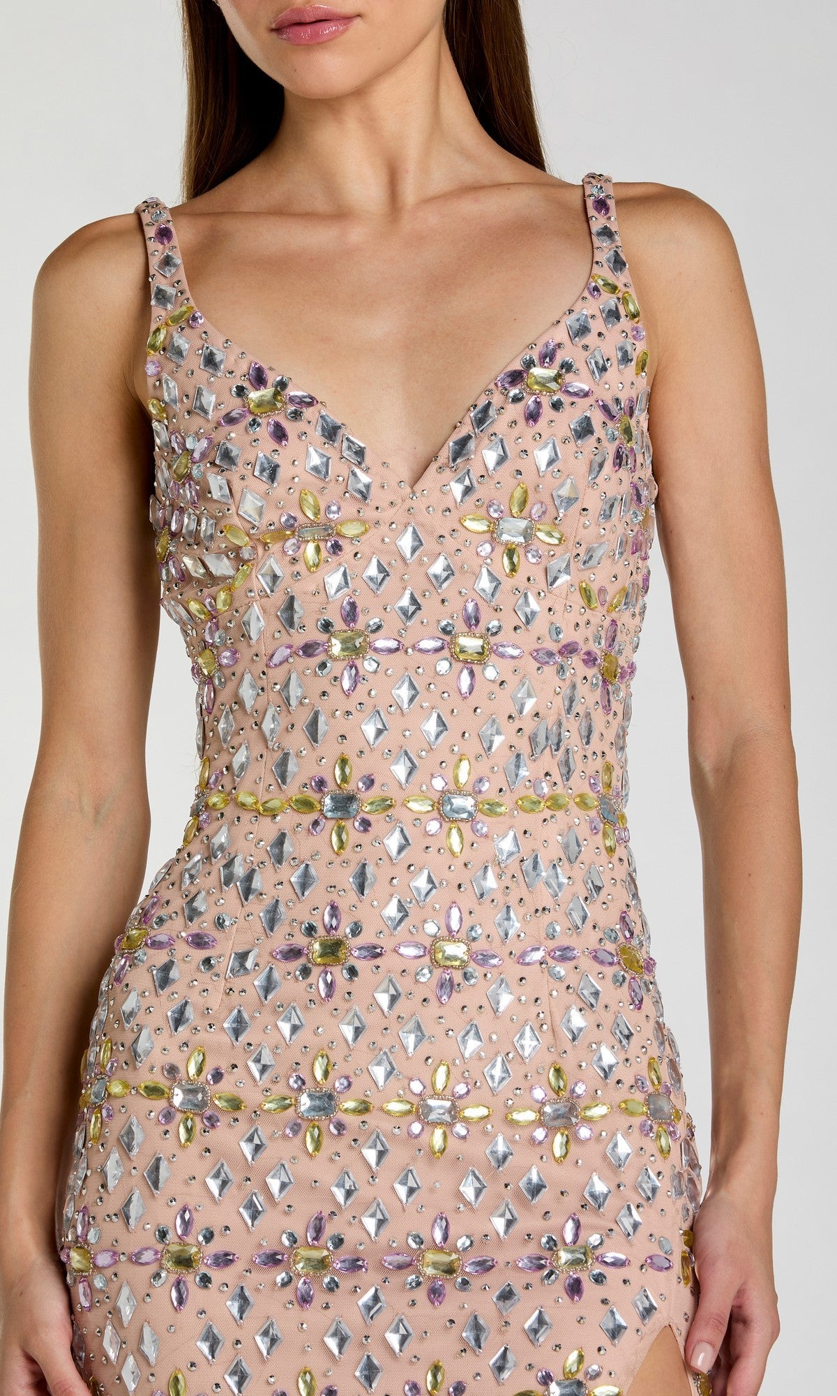 A woman wearing the Mac Duggal 10155 long formal dress, a sleeveless and fitted design crafted from nude mesh and embellished with reflective and colorful crystal beads in various shapes.