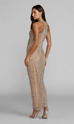 Woman in a fitted, sleeveless Mac Duggal 10206 long formal dress in nude-silver with draped beadwork, standing in heels and facing away while looking over her shoulder against a plain background.