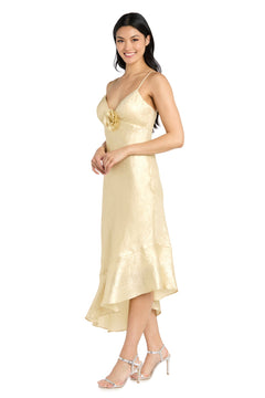 A woman stands smiling in the gold, sleeveless, v-neck Shimmer Midi Semi-Formal Dress: Morgan 10251 with a ruffled hem and strappy high heels. Ideal for any occasion, this elegant midi dress is perfect for a chic semi-formal look.