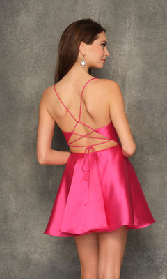 A woman in the Dave & Johnny Backless Short Pink Homecoming Dress with a beaded waistband and crisscross open back stands facing away from the camera against a textured gray wall.