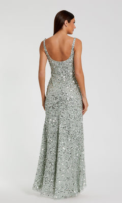 A woman faces away, wearing the Mac Duggal 10705 Sparkly Long Sequin Formal Dress with a fitted silhouette and dramatic low back, set against a plain light background.