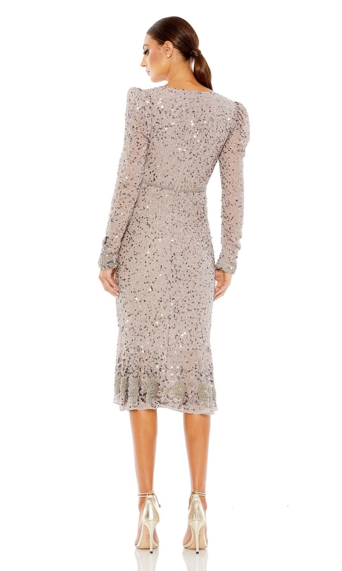 A woman faces away in a fitted, long-sleeve sequin dress with a ruffled hem and metallic heels—an elegant look inspired by the Mac Duggal 10740 Long Sleeve Wedding-Guest Dress.