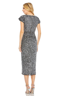A woman stands facing away in the Mac Duggal 10766 Midi Sequin Wedding Guest Dress with silver sequins and high-heeled sandals, highlighting the dress's back.