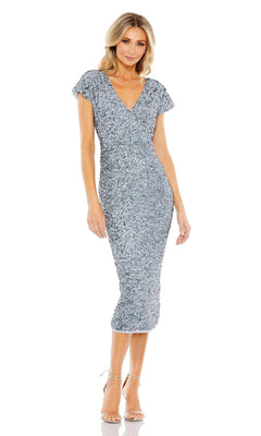 A woman stands in strappy heels against a white background, wearing the Mac Duggal 10766 Midi Sequin Wedding Guest Dress—a silver, cap-sleeve, V-neck midi cocktail dress.