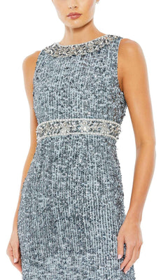 A woman stands against a plain white background wearing the Mac Duggal 10839—a long blue sequin formal gown featuring beaded detailing at the neckline and waist, embodying refined mother of the bride elegance.