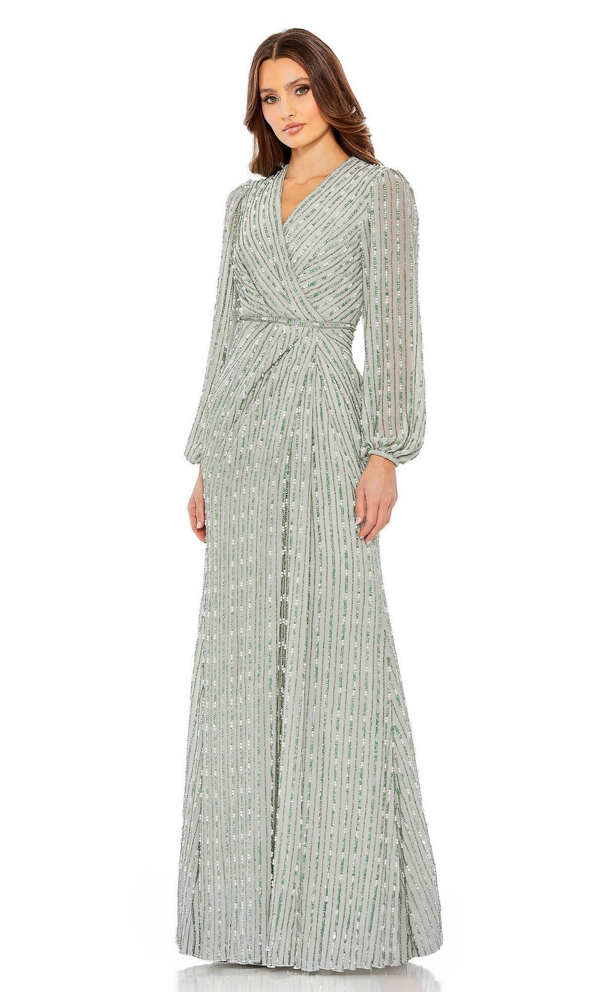 A woman in a sage Mac Duggal 10871 long formal dress with long sleeves, vertical beaded stripes, and a wrapped bodice stands against a white background.