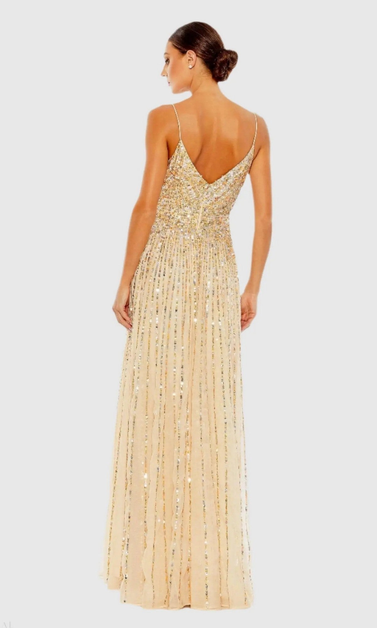 Woman wearing the Mac Duggal 10928 long formal dress, a sleeveless gown with gold sequins and a low V-back, standing against a plain light background.