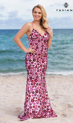 A woman in the Faviana Floral-Sequin Long Prom Dress 11000 stands on the beach with the ocean behind her. The "FAVIANA" logo appears in the top right corner.