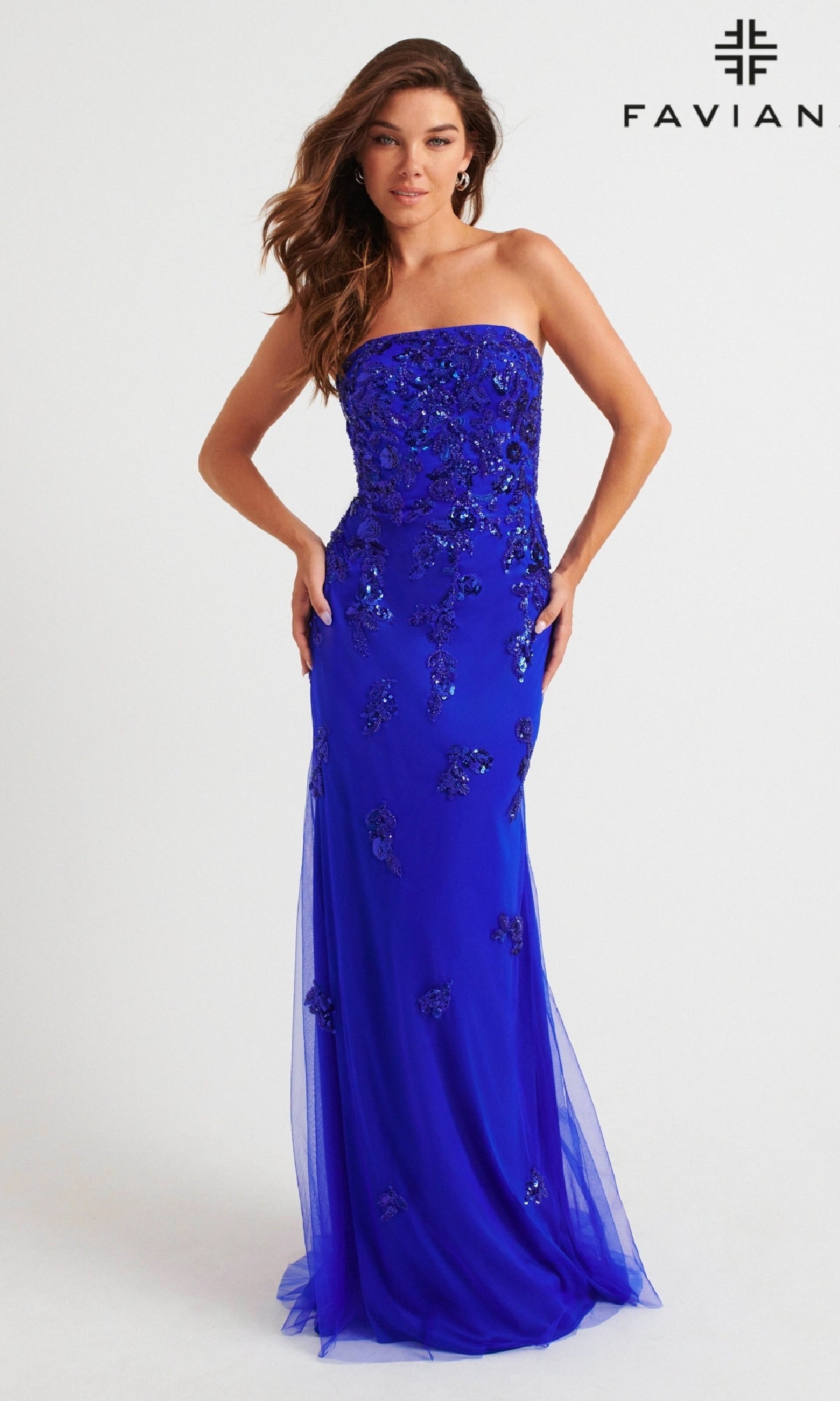 A woman wears the Faviana Strapless Long Beaded Prom Dress 11004 in royal blue, standing against a white background with the Faviana logo in the top right corner.