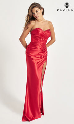 A woman stands against a plain white background wearing the Strapless Sweetheart Faviana Long Prom Dress 11009 in ruched red stretch satin with a thigh-high slit. The "Faviana" brand name appears in the corner.