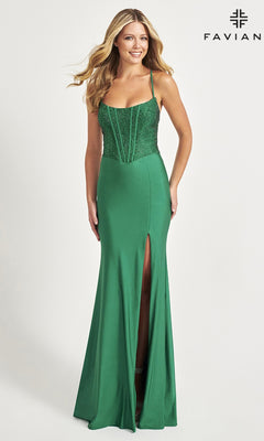 A woman stands smiling against a plain background in the Beaded-Corset-Bodice Faviana Long Prom Dress 11011, a green gown with thin straps, a slit, and a fitted, beaded bodice that adds elegant texture.