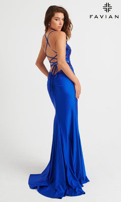 A woman poses in the Faviana Tonal-Embroidered Long Prom Dress 11017, a fitted, floor-length royal blue gown with sequin details and a lace-up open back, against a white backdrop featuring the Faviana logo—ideal for your next formal event.