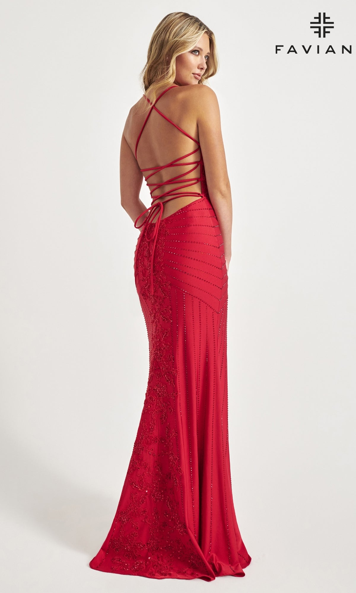 A woman in a fitted red Lace-Up Long Faviana Beaded Prom Dress 11021, featuring a strappy open back and beaded details, stands facing away from the camera. 