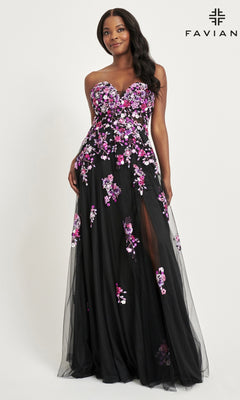 A woman models the Faviana Long Black Strapless Prom Dress 11028, featuring pink and purple floral embroidery and a thigh-high slit, against a plain background with the Faviana logo in the top right corner.