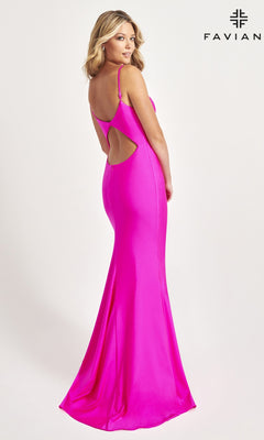 A woman poses in front of a plain background wearing the Faviana Classic Mermaid Long Prom Dress 11047, a bright pink, floor-length gown with thin straps and a back cut-out. "FAVIAN" appears in the upper right corner.