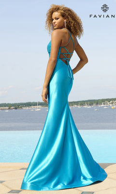 A woman stands by a pool in a shiny turquoise Faviana Lace-Up Long Satin Prom Dress 11051, facing away. A lake and boats are in the background, and "FAVIAN" appears at the top right.