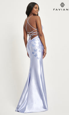 A woman models the Faviana Bead-Butterfly Long Satin Prom Dress 11053 in light purple, showcasing a lace-up open back and beaded butterfly embroidery, standing before a plain background with the Faviana logo in the corner.