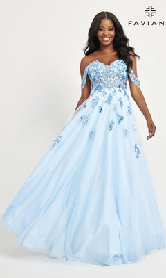 A woman wears the Faviana Off-Shoulder Long A-Line Prom Dress 11059, a light blue gown with floral embroidery and a flowing skirt, standing against a plain background. "Faviana" appears in the top right corner.