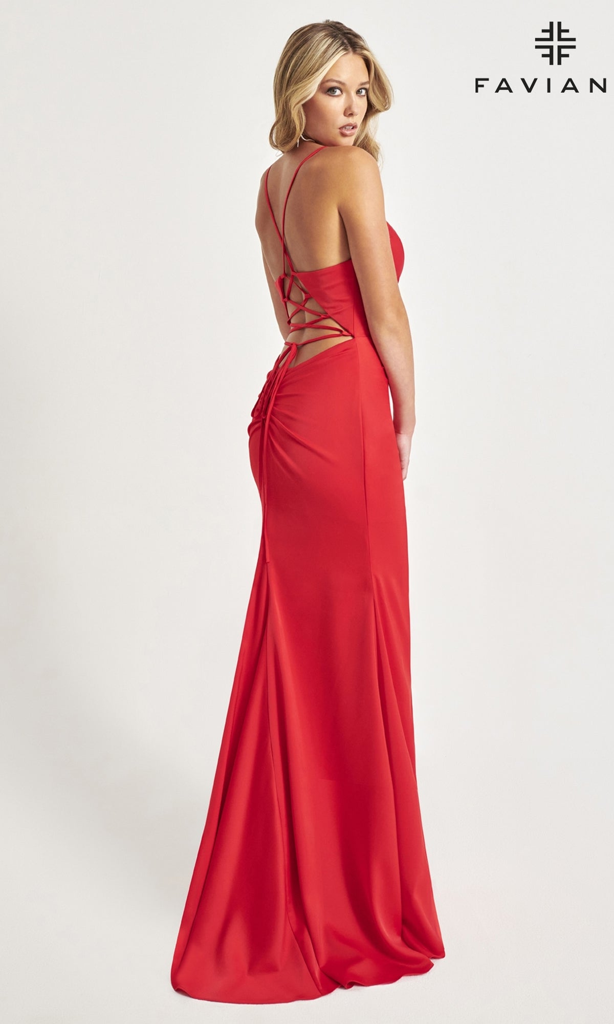 A woman wearing the Faviana Long Satin Formal Prom Dress 11068 with crisscross straps stands facing away, looking over her shoulder. The 